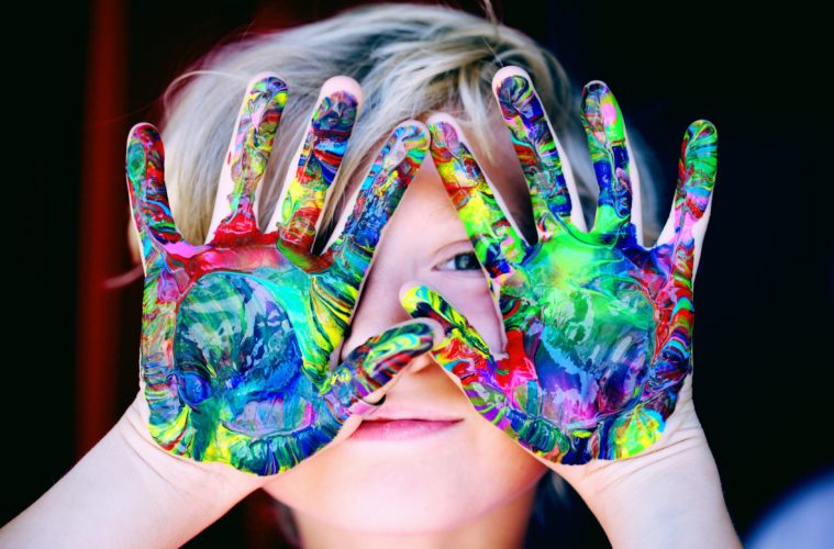 photo d'un enfant avec des taches de peinture sur les mains